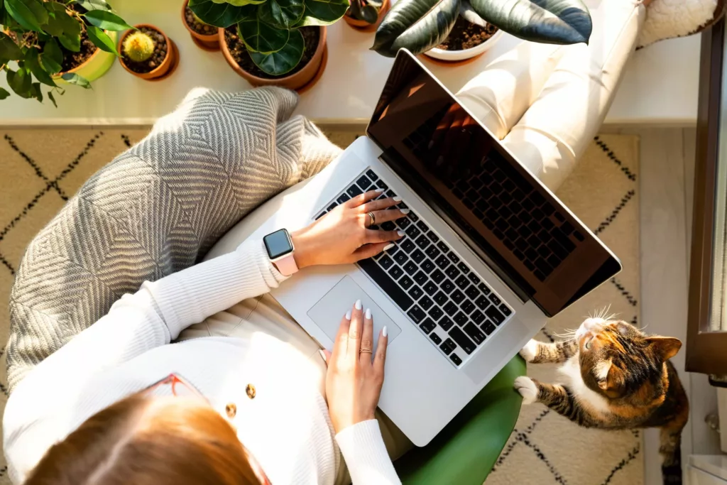 Nainen istuu tietokone sylissään